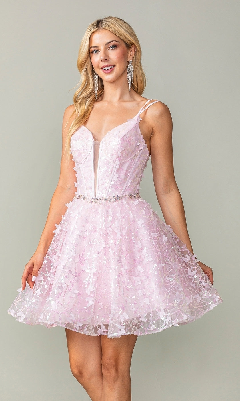 A woman wearing the Three-D Short Butterfly Homecoming Dress 3350, a light pink sleeveless dress with floral appliqués, a translucent corset-style bodice, and thin straps, poses against a neutral background.